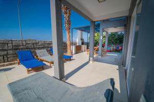 een patio met twee blauwe stoelen op een huis bij Patara Evleri in Patara