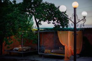 a patio with a canopy with candles and a tree at Guest House Issyk-Kul Nomad in Bosteri