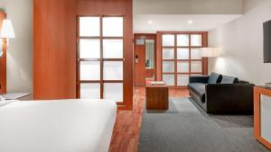 a living room with a couch and a tv at AC Hotel La Rioja by Marriott in Logroño