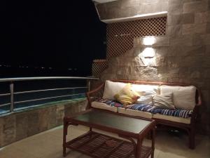 a couch sitting on a balcony with a table at Chalet On the Beach in Alexandria