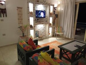 a living room with a couch and a tv on a wall at Chalet On the Beach in Alexandria