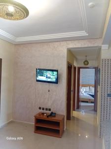 a living room with a tv on a wall at Appart-Hotel SOFINES in Agadir