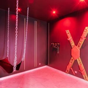 une pièce éclairée en rouge et une pièce avec des chaînes dans l'établissement Villa avec jacuzzi privatif, à Saint-Cyr-lʼÉcole