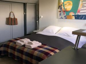 pokój hotelowy z 2 łóżkami i ręcznikami na kocu w obiekcie Studio 29 w mieście Honfleur