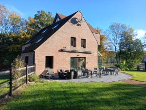 een gebouw met tafels en stoelen ervoor bij Gite des étangs de Saint Bale in Vrigne-aux-Bois