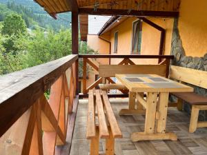 a picnic table on the balcony of a house at Захід сонця in Slavske