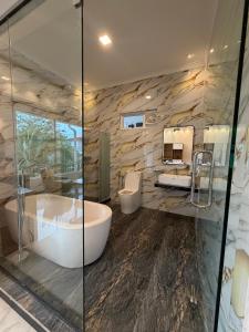 a bathroom with two sinks and a tub and two mirrors at White Land City Hotel in Dambulla
