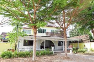a house with two trees in front of it at OYO 674 Greenery Home in Ban Nam Sai