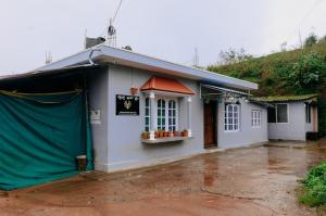 a white building with a green tarp around it at WildWood Stay in Madikeri