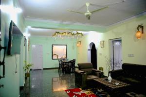 a living room with green walls and a ceiling at WildWood Stay in Madikeri