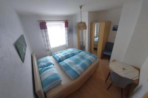 une chambre avec un lit, une fenêtre et un miroir dans l'établissement Gästehaus Bader, à Garmisch-Partenkirchen