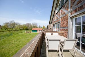 a balcony with a table and chairs on a brick building at Haus an der Düne Wohnung 9 in Lobbe