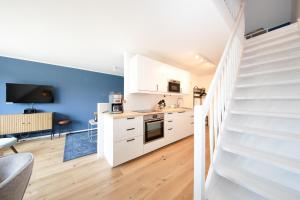 a kitchen with a staircase and a living room at Haus an der Düne Wohnung 9 in Lobbe