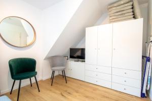 a bedroom with a white cabinet and a mirror at Haus an der Düne Wohnung 9 in Lobbe +9 photos