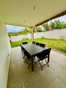 a black table and chairs on a patio at LA RDC Villa 3 ch jacuzzi Saint-Pierre in Saint-Pierre
