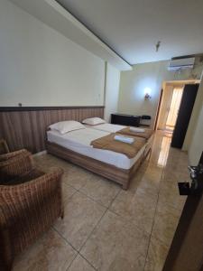 a bedroom with a large bed and a chair at Halim Living in Sukarami