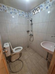 a bathroom with a toilet and a sink at Halim Living in Sukarami