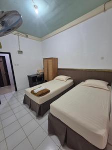 a bedroom with two beds in a room at Halim Living in Sukarami +16 photos