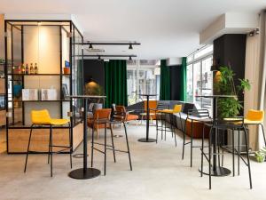 a bar with yellow chairs and tables in a room at Ibis Pau Centre in Pau