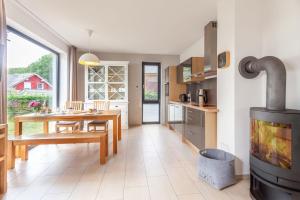 a kitchen and dining room with a wood stove at Strandhaus Wolkenlos in Ostseebad Sellin