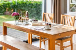a wooden table with plates of food and flowers on it at Strandhaus Wolkenlos in Ostseebad Sellin