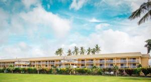 een groot gebouw met palmbomen op de achtergrond bij Insel Fehmarn Hotel in Apia