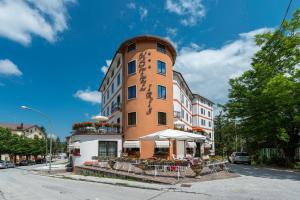 a building with a table and chairs in front of it at Hotel Iris in Roccaraso