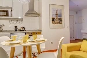 a kitchen with a table and chairs in a kitchen at Bracara Guest House "Campo Novo" in Braga