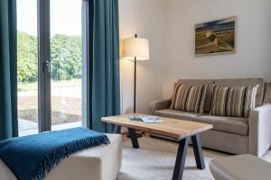 a living room with a couch and a table at Ferienhaus Baltic in Lobbe in Lobbe +28 photos