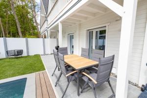 a patio with a wooden table and chairs next to a house at Ferienhaus Vitamin Sea in Ostseebad Sellin