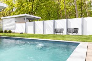 a swimming pool with two chairs next to a fence at Ferienhaus Vitamin Sea in Ostseebad Sellin +25 photos