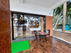 a room with a table and two chairs and a window at Navasharada's White Sand Beach House in Udupi