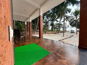 a living room with a green rug on the floor at Navasharada's White Sand Beach House in Udupi