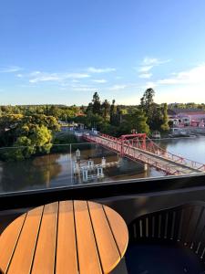 een tafel op een balkon met uitzicht op een brug bij Carmelo Postal by Puerto Dijama in Carmelo