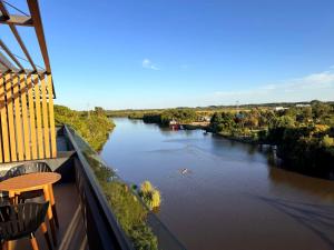 iemand die vanaf een balkon in een kajak een rivier afvaart bij Carmelo Postal by Puerto Dijama in Carmelo