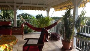 a hammock on the porch of a house at villa piscine majoma in Sainte-Anne