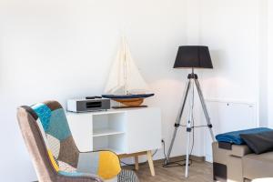 ein Wohnzimmer mit einem Stuhl und einem Segelboot an der Wand in der Unterkunft Penthouse Heimathafen in Lauterbach in Lauterbach