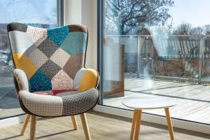 ein Stuhl mit einer Steppdecke darauf neben einem Fenster in der Unterkunft Penthouse Heimathafen in Lauterbach in Lauterbach
