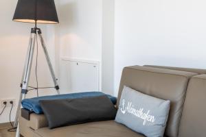 eine Lampe neben einem Sofa mit einem Kissen in der Unterkunft Penthouse Heimathafen in Lauterbach in Lauterbach