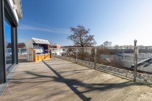 eine Holzterrasse mit einem Zaun auf einem Gebäude in der Unterkunft Penthouse Heimathafen in Lauterbach in Lauterbach + 17 Fotos