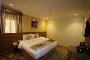 a hotel room with a bed and a television at Maysan AL Multaqa Hotel in Al Masfalah
