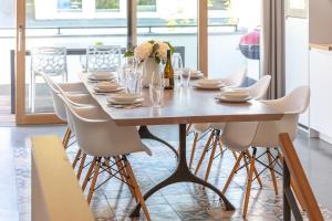 een eettafel met witte stoelen en een tafel met een stoel bij Villa Baltic Pearl Penthouse in Ostseebad Sellin +22 foto's