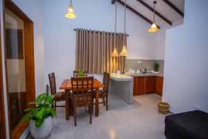 a kitchen and dining room with a table and chairs at The Clouds Ahangama in Ahangama