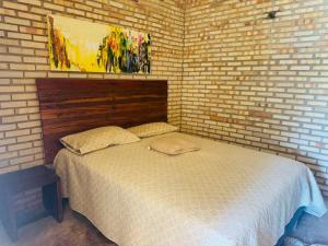 a bedroom with a bed in a brick wall at Casa De Praia 9 quartos Em Aguas Belas, CE in Cascavel