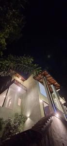 een gebouw met lichten aan de zijkant 's nachts bij mountain retreat in Kandy +3 foto's