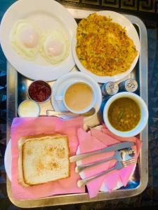 a tray of food with eggs and bread and soup at Gulberg Residency Hotel in Lahore