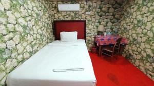 una camera da letto con un letto bianco e un tavolo di Hotel Golden Bird a Dhaka