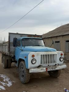 een blauwe truck geparkeerd voor een gebouw bij Ali Guest House in Kara-Koo