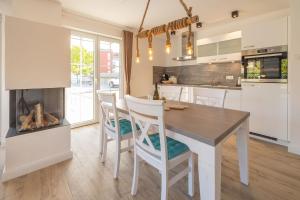 une cuisine avec une table et des chaises ainsi qu'une cheminée dans l'établissement Alte Fischfabrik SeePerle, à Lauterbach