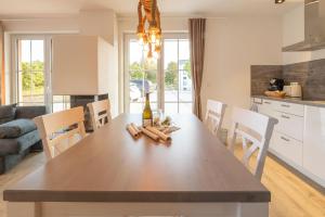 une cuisine et une salle à manger avec une table avec une bouteille de vin dans l'établissement Alte Fischfabrik SeePerle, à Lauterbach